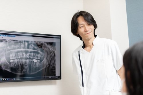 レントゲン画像を見せながら患者様に説明する院長